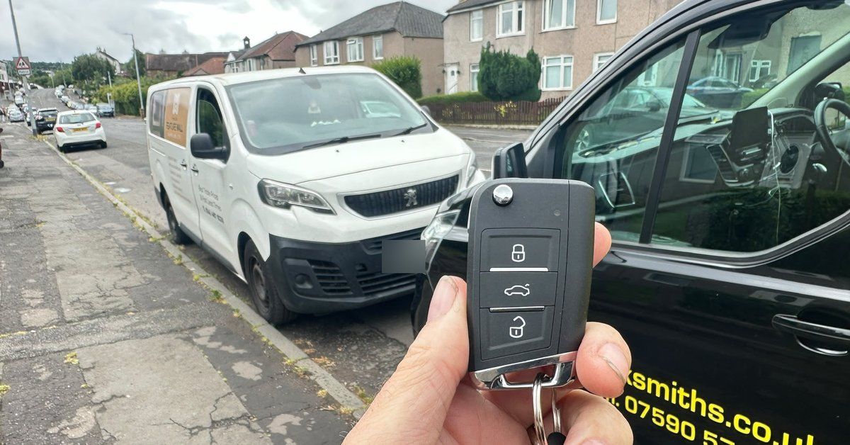 A new spare flip car key held beside the LKC Locksmiths van